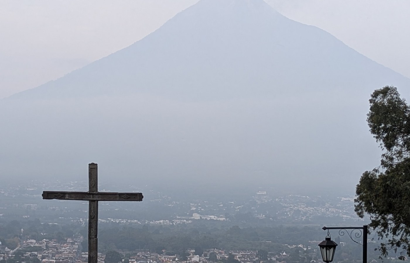 Cross overlooking Antigua, Guatemala with volcano in the background